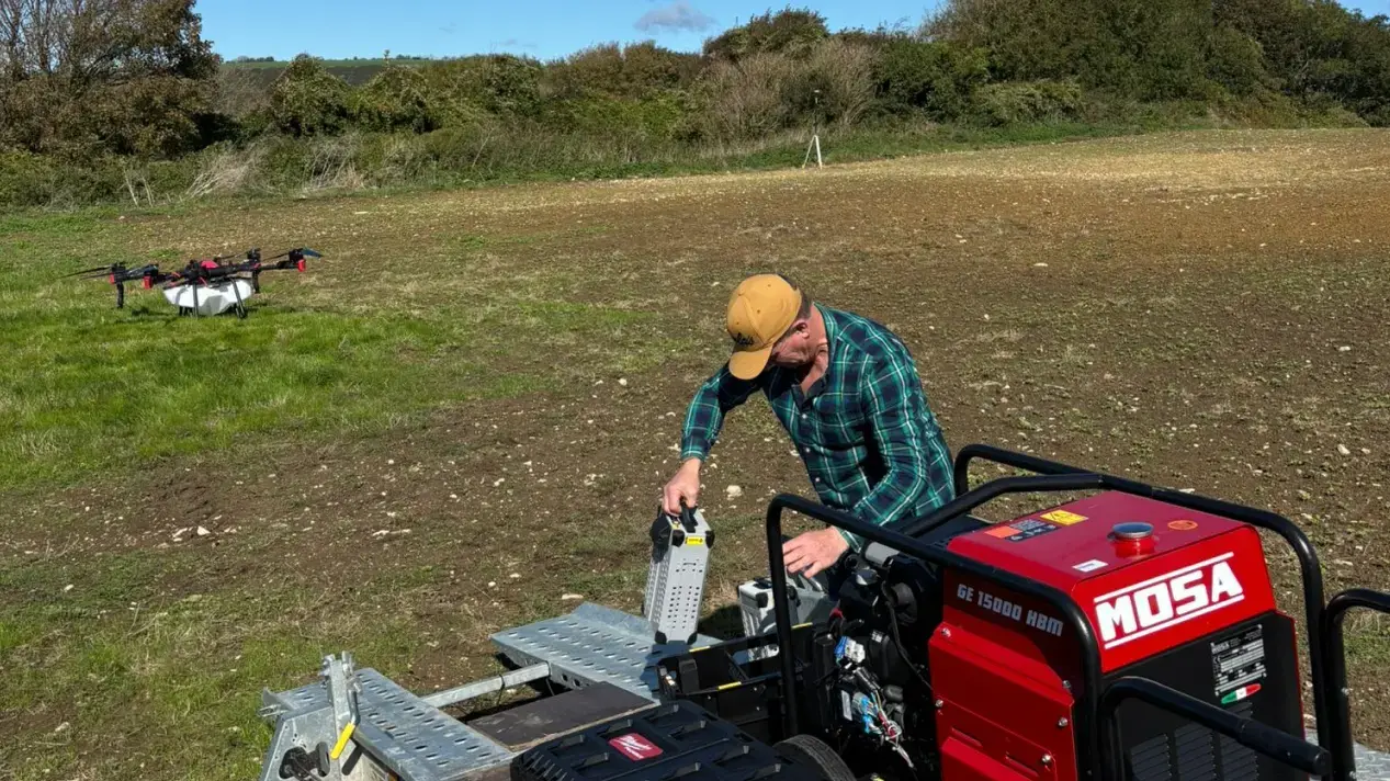 A drone operator prepares a drone for flight.
