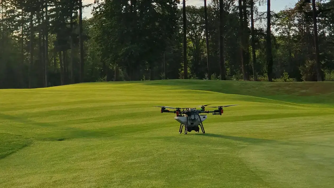 A ground shot of a golf course with an agri drone preparing for takeoff.