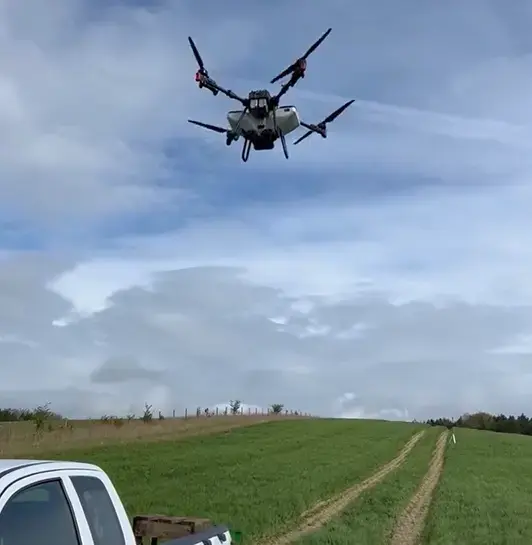 XAG p100 Drone spreading product over young wheat field