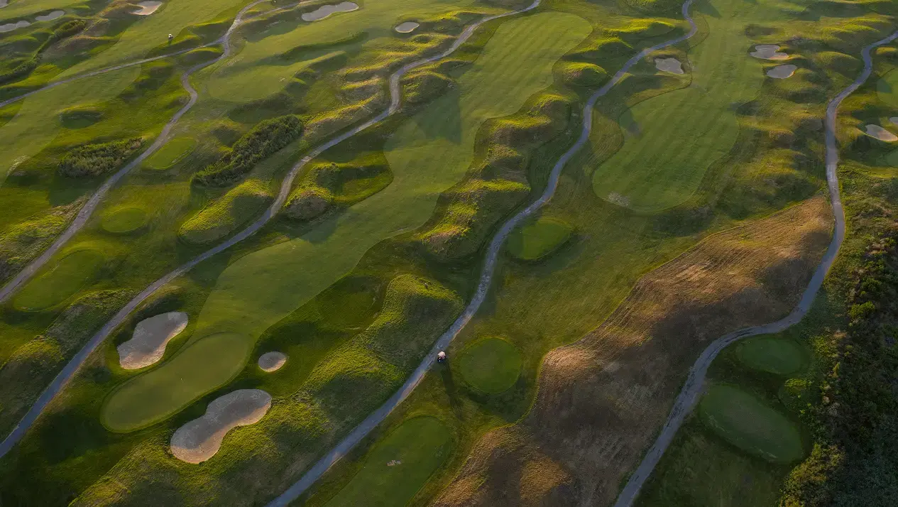 An aerial view of a golf course showing undulating terrain that's hard to seed efficiently